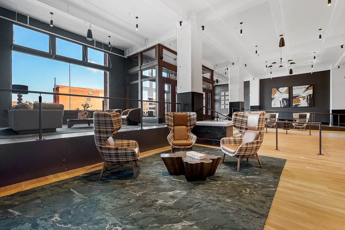 Lobby with plaid wingback chairs, eclectic decor, and large windows.