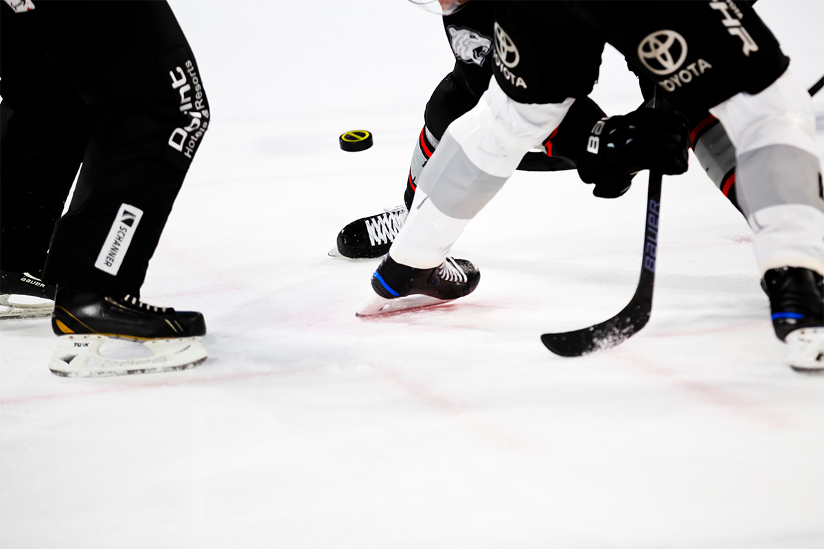 Hockey players going for the puck on ice.